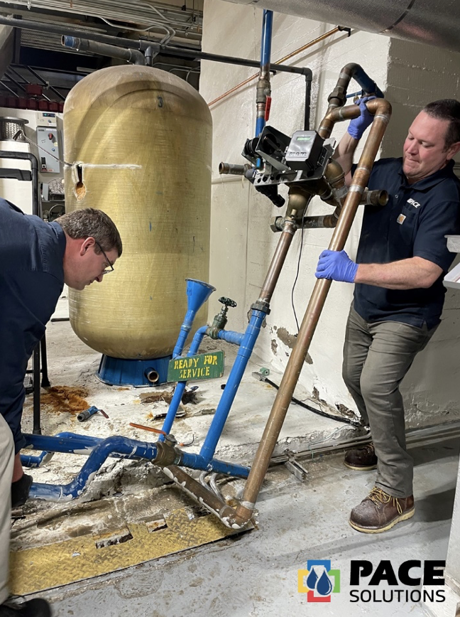 Dos hombres trabajando en un depósito de agua