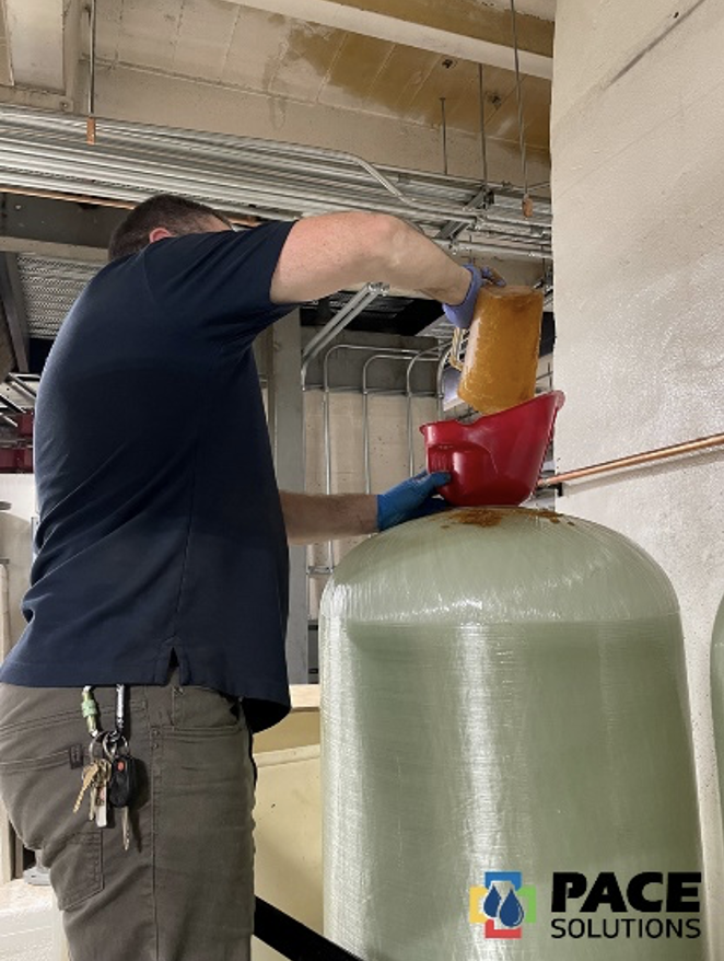 Un empleado de Pace está instalando descalcificadores en los depósitos de agua